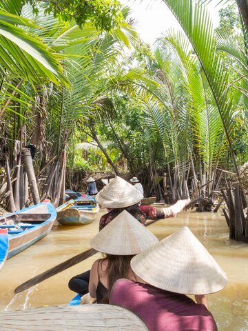 Navigate the Mekong Delta's labyrinthine canals in a traditional sampan.
