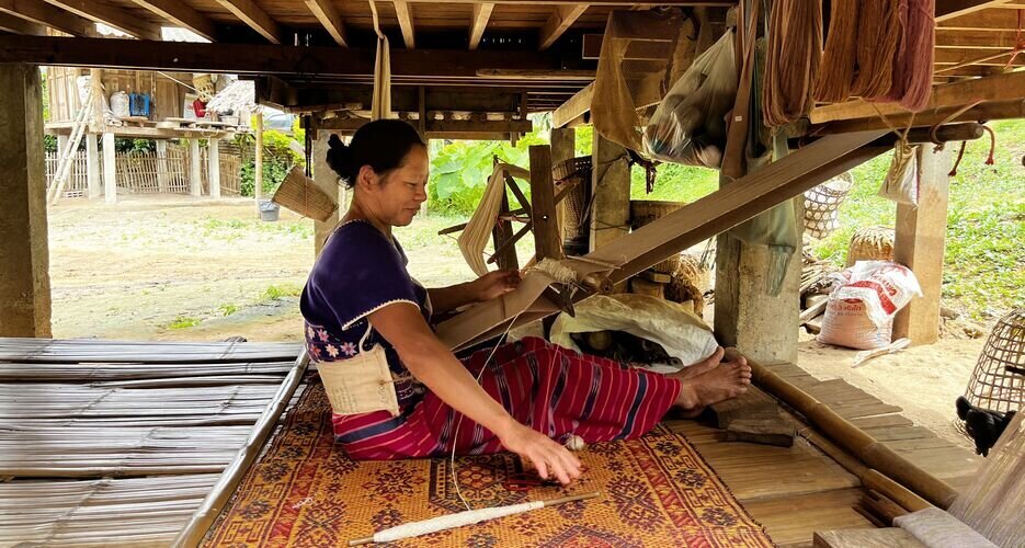 A local Karen woman weaving traditional textiles by hand.
