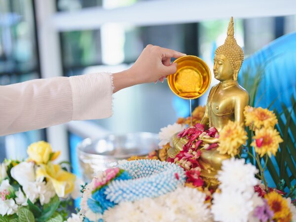 Gently pouring scented water over the
sacred Buddha images.
