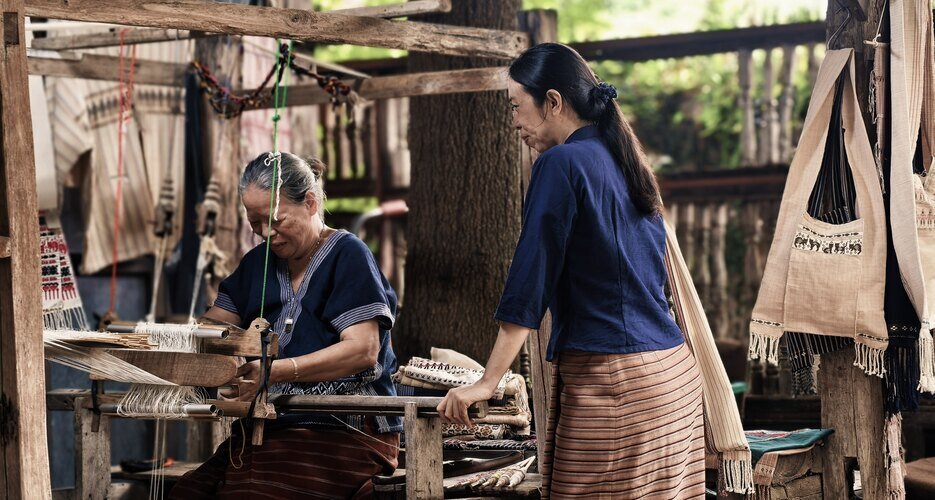 A Karen woman is weaving.